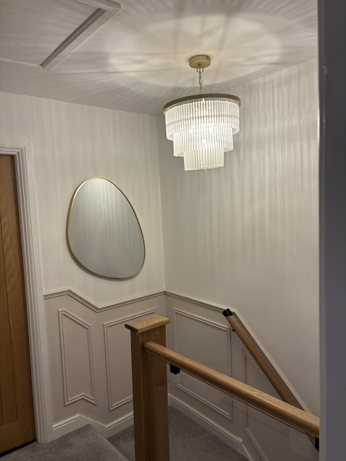 Crystal chandelier hung in a panelled stairwell